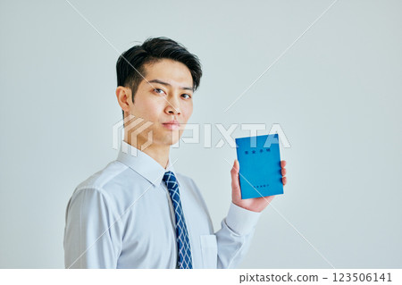 一名 20 多歲的年輕人拿著一本退休金簿 123506141
