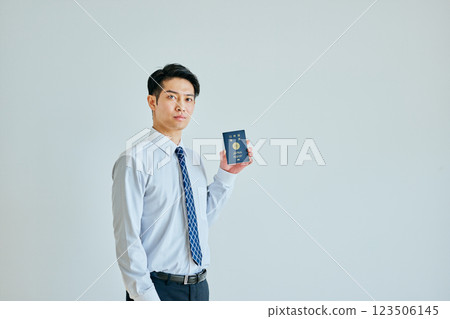 A young man in his twenties holding a passport A young man in his twenties holding a passport 123506145
