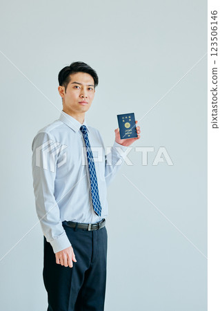 A young man in his twenties holding a passport A young man in his twenties holding a passport 123506146