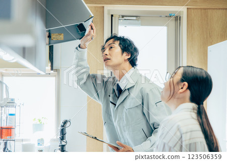 A worker inspecting a ventilation fan 123506359