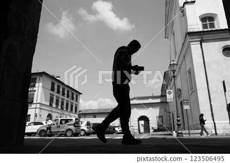 Silhouetted man walking distracted by smartphone 123506495