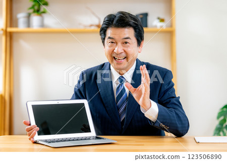 Middle-aged businessman explaining online Middle-aged businessman explaining online 123506890
