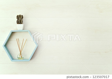 hexagonal wooden shelf on the wall with flowers and aroma diffuser. mock up hexagonal wooden shelf on the wall with flowers and aroma diffuser. mock up 123507017