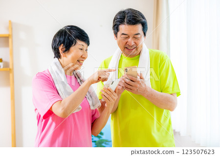 Senior men and women who look at their smartphones after exercise and worry about the results 123507623