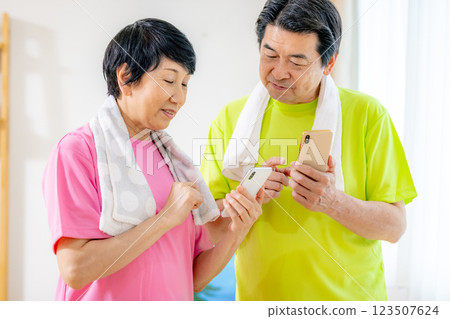 Senior men and women who look at their smartphones after exercise and worry about the results 123507624