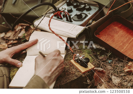 Russian Soviet Infantry Red Army Soldier In World War II using Russian Soviet Portable Radio Transceiver In Trench Entrenchment In Spring Autumn Forest. 4K. Headphones And Telegraph Key. Close Up Russian Soviet Infantry Red Army Soldier In World War II using Russian Soviet Portable Radio Transceiver In Trench Entrenchment In Spring Autumn Forest. 4K. Headphones And Telegraph Key. Close Up 123508538