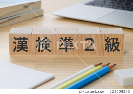 A block with the words "Kanji Examination Level 2" written on it on the desk A block with the words "Kanji Examination Level 2" written on it on the desk 123509290