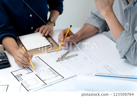 Architect and engineer are discussing and viewing and editing plans 123509764