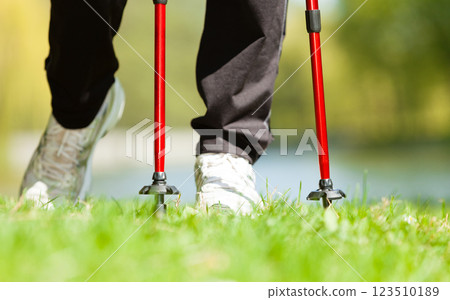 Nordic walking. Female legs hiking in the park. 123510189