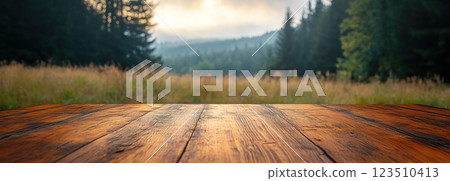 Wooden Table Surface with Sunset Blurry Cityscape and Nature Background, Warm Tones, and Soft Focus Lights Creating a Cozy Atmosphere for Relaxation 123510413