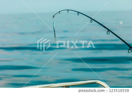 saltwater fishing - rod with wobbler and blue sea water saltwater fishing - rod with wobbler and blue sea water 123510539