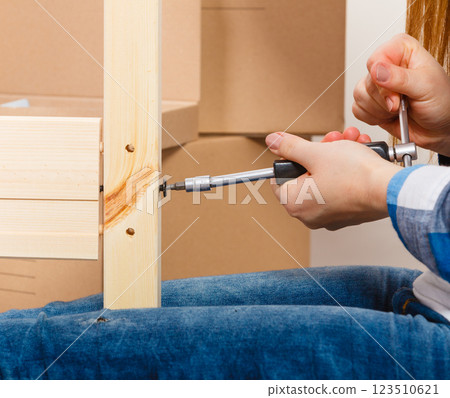 Assembling wood furniture using scredriver. DIY. 123510621