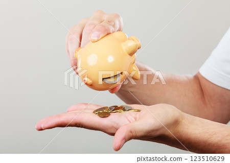 Male hands with coins and piggybank 123510629