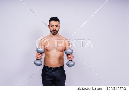 Athletic man doing exercises with dumbbell at biceps on white background. Strength and motivation Athletic man doing exercises with dumbbell at biceps on white background. Strength and motivation 123510730