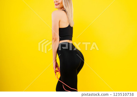 Fitness and sport concept. Portrait of smiling young woman wearing sportswear posing isolated 123510738