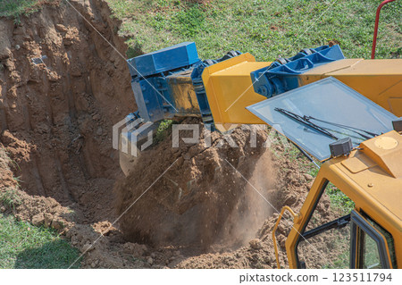 Bucket excavator digs a pit in the ground Bucket excavator digs a pit in the ground 123511794