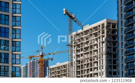 Construction of modern high-rise building in urban area. Crane at work on unfinished condo, part of 123511908