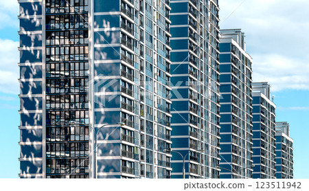 Modern high-rise building in downtown metropolis. Glass facade with views of blue sky and clouds, 123511942