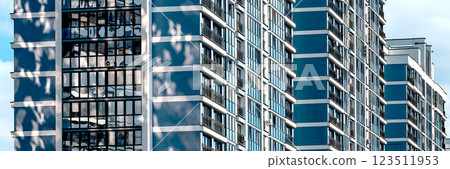 Modern high-rise condominium in downtown city. Concrete facade with large windows offering views of Modern high-rise condominium in downtown city. Concrete facade with large windows offering views of 123511953