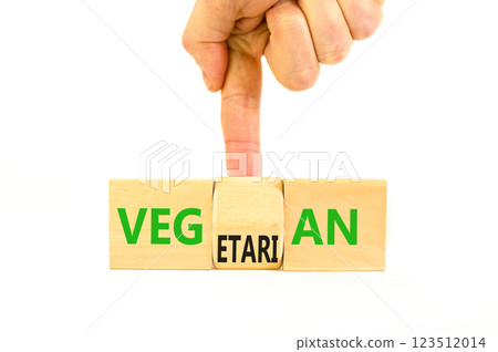 Vegetarian or vegan symbol. Concept words Vegetarian Vegan on wooden block. Beautiful white table white background. Vegan hand. Healthy lifestyle vegetarian or vegan concept. Copy space. 123512014