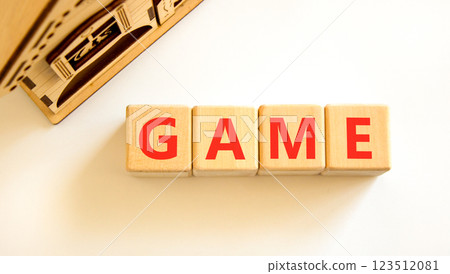 Game symbol. Concept word Game on beautiful wooden blocks. Beautiful wooden house. Beautiful white table white background. Business, lifestyle and game concept. Copy space. Game symbol. Concept word Game on beautiful wooden blocks. Beautiful wooden house. Beautiful white table white background. Business, lifestyle and game concept. Copy space. 123512081