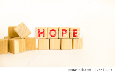 Hope symbol. Concept word Hope on beautiful wooden blocks. Beautiful white table white background. Business, lifestyle, support and hope concept. Copy space. 123512083