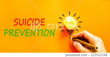 Suicide prevention symbol. Concept words Suicide prevention on beautiful orange paper. Psychologist hand. Beautiful orange table orange background. Psychological suicide prevention concept. Copy space Suicide prevention symbol. Concept words Suicide prevention on beautiful orange paper. Psychologist hand. Beautiful orange table orange background. Psychological suicide prevention concept. Copy space 123512148