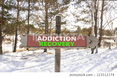 Addiction recovery symbol. Concept words Addiction recovery on beautiful wooden road sign. Beautiful snow forest background. Psychology addiction recovery concept. Copy space. 123512174