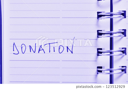 Handwritten word DONATION on notebook 123512929
