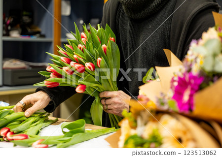 Florist arranging red and white tulips in flower shop Florist arranging red and white tulips in flower shop 123513062