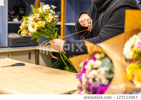 Florist preparing bouquets of fresh flowers in a flower shop 123513063