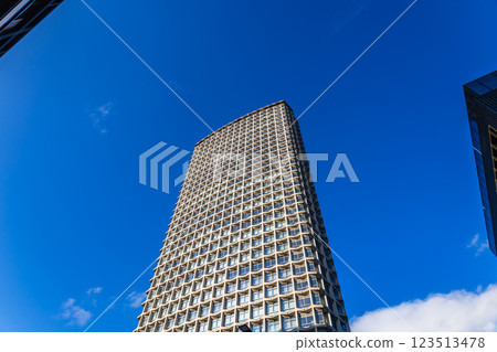 Modern skyscraper against a blue sky in an urban cityscape, low angle view 123513478