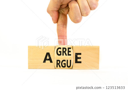 Agree or argue symbol. Concept words Agree or Argue on wooden block. Beautiful white table white background. Businessman hand. Business agree or argue concept. Copy space. Agree or argue symbol. Concept words Agree or Argue on wooden block. Beautiful white table white background. Businessman hand. Business agree or argue concept. Copy space. 123513633