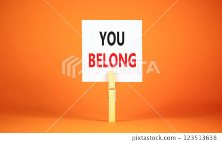Belonging and you belong symbol. Concept words You belong on beautiful white paper on wooden clothespin. Beautiful orange background. Business belonging and you belong concept. Copy space. Belonging and you belong symbol. Concept words You belong on beautiful white paper on wooden clothespin. Beautiful orange background. Business belonging and you belong concept. Copy space. 123513638