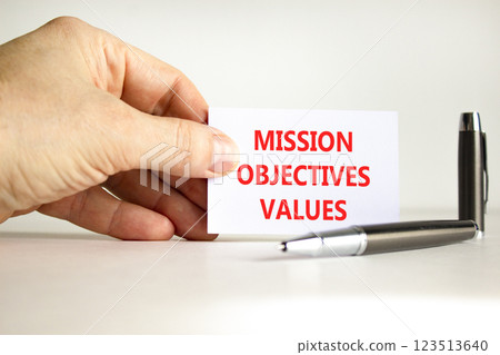 Mission objectives values symbol. Concept words Mission Objectives Values on beautiful white card. Beautiful white background. Businessman hand. Business mission objectives values concept. Copy space. Mission objectives values symbol. Concept words Mission Objectives Values on beautiful white card. Beautiful white background. Businessman hand. Business mission objectives values concept. Copy space. 123513640