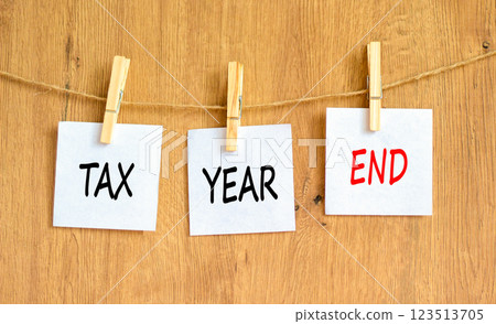 Tax year end symbol. Concept words Tax year end on beautiful white paper on clothespin. Beautiful wooden background. Business tax year end concept. Copy space. 123513705
