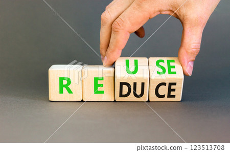 Reuse or reduce symbol. Concept words Reuse Reduce on wooden block. Beautiful grey table grey background. Businessman hand. Business reuse or reduce concept. Copy space. 123513708