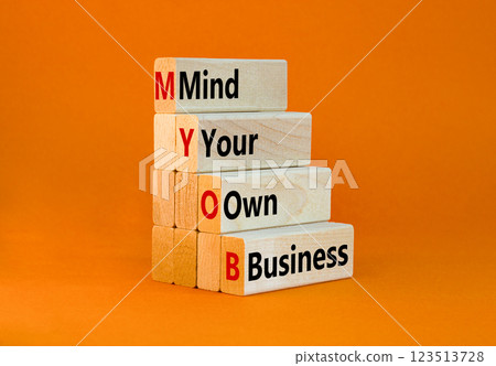 MYOB mind your own business symbol. Concept word MYOB Mind Your Own Business on beautiful wooden blocks. Beautiful orange background. Business MYOB mind your own business concept. Copy space. 123513728