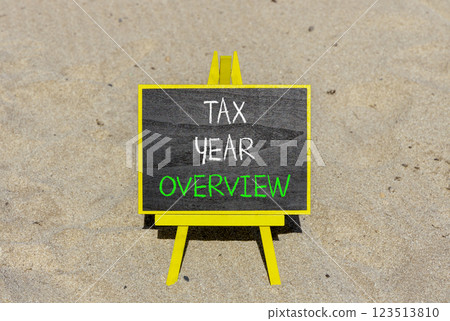 Tax year overview symbol. Concept words Tax year overview on beautiful black yellow blackboard. Beautiful sand beach background. Business tax year overview concept. Copy space. 123513810