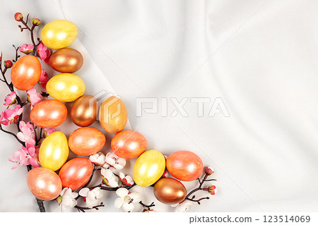 Easter eggs on a light elegant background with sakura branches, ideas for homemade Easter preparations. Marble eggs painted with golden turmeric, Easter celebration concept 123514069