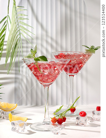 Lemonade cocktail with tequila, gin, rum, vodka, liqueur, lime, ice and fresh raspberries, bar and party concept, advertising card for restaurant and cafe, elegant background with shadows, . Lemonade cocktail with tequila, gin, rum, vodka, liqueur, lime, ice and fresh raspberries, bar and party concept, advertising card for restaurant and cafe, elegant background with shadows, . 123514400