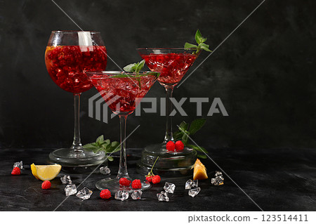 Lemonade cocktail with tequila, gin, rum, vodka, liqueur, lime, ice and fresh raspberries, bar and party concept, restaurant and cafe advertising card, black background, selective focus 123514411