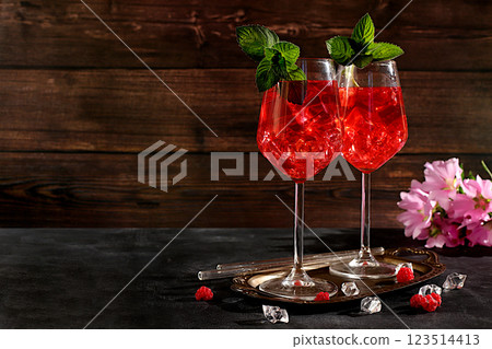 Royal alcoholic lemonade cocktail with lime, ice and fresh raspberries, bar and party concept, restaurant and cafe advertising card, black background, selective focus Royal alcoholic lemonade cocktail with lime, ice and fresh raspberries, bar and party concept, restaurant and cafe advertising card, black background, selective focus 123514413