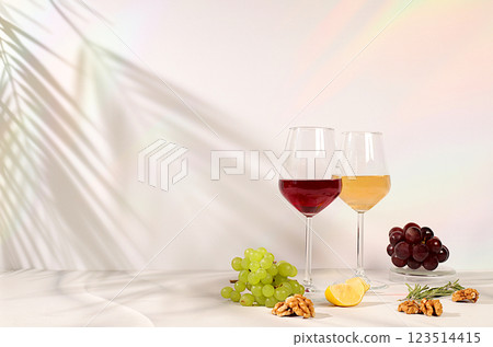 Tasting noble varieties of red and white wine in glasses with grape varieties, nuts and rosemary, concept of wine tasting and summer party. Advertising banner for cafe and restaurant, modern still 123514415