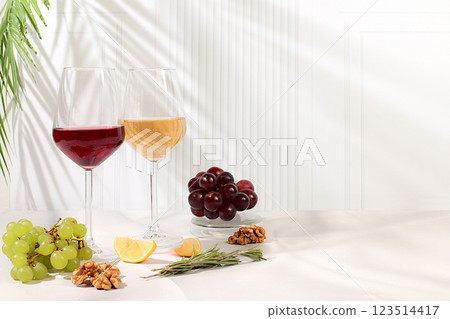 Tasting noble varieties of red and white wine in glasses with grape varieties, nuts and rosemary, concept of wine tasting and summer party. Advertising banner for cafe and restaurant, modern still 123514417
