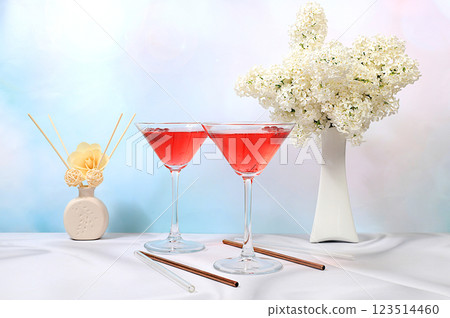 Festive alcoholic cocktail martini in glasses on a bright background with a bouquet of white lilacs, summer bar concept, alcoholic drinks at a party, restaurant and cafe advertising, selective focus Festive alcoholic cocktail martini in glasses on a bright background with a bouquet of white lilacs, summer bar concept, alcoholic drinks at a party, restaurant and cafe advertising, selective focus 123514460