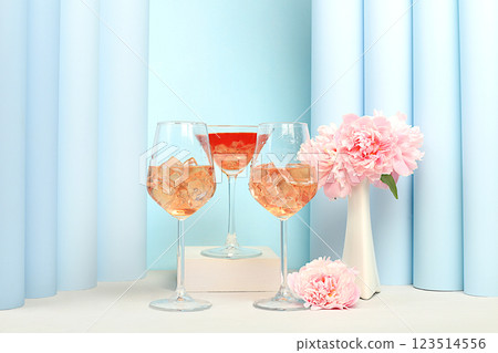 Modern summer still life with alcoholic cocktail Aperol spritz, champagne, pink martini and peony flowers on elegant modern background, minimal concept for bar and holiday party, cafe, advertising Modern summer still life with alcoholic cocktail Aperol spritz, champagne, pink martini and peony flowers on elegant modern background, minimal concept for bar and holiday party, cafe, advertising 123514556