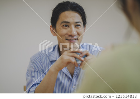 A smiling man in his 40s talking to a woman 123514818