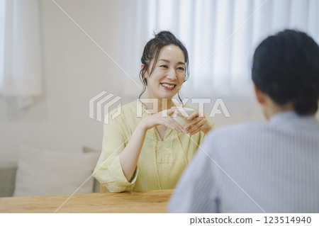 A smiling woman in her 40s talking to a man 123514940