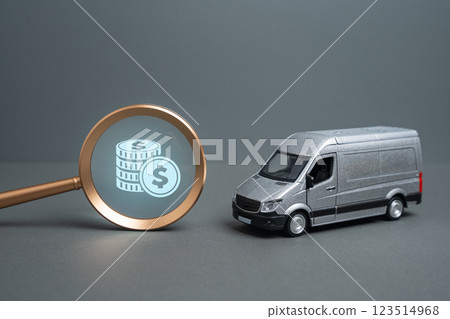 Van and magnifying glass with money. Concept of transportation cost and logistics. Fuel prices, taxes, and operational expenses affect transportation industry profitability and efficiency. 123514968
